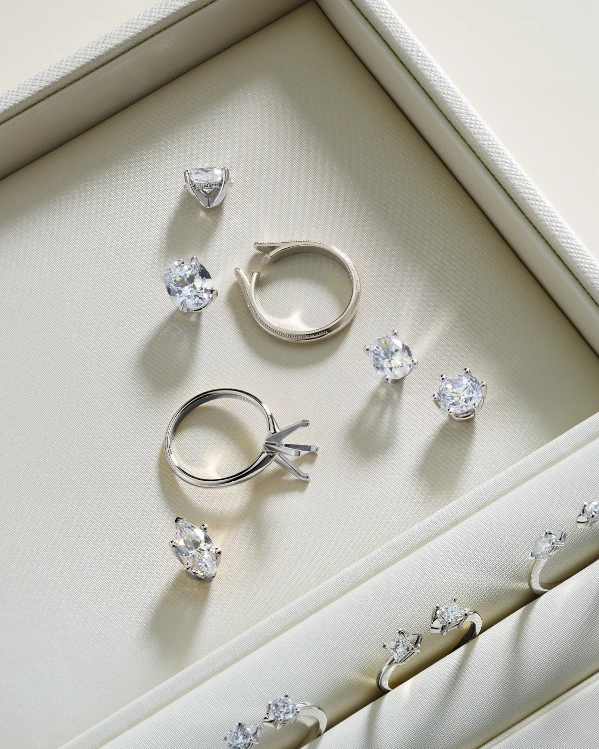 Jewelry box with loose diamonds and ring settings on display.