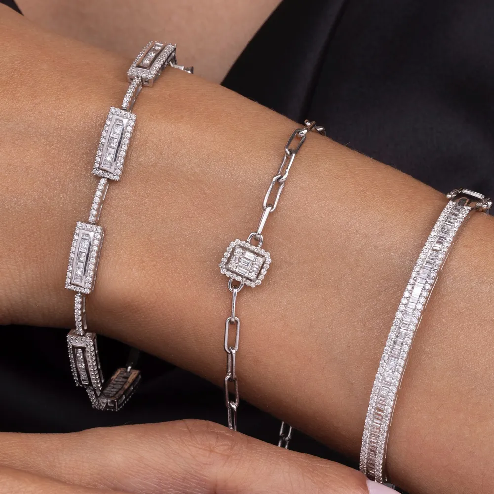 Elegant silver bracelets with diamond accents on a wrist.