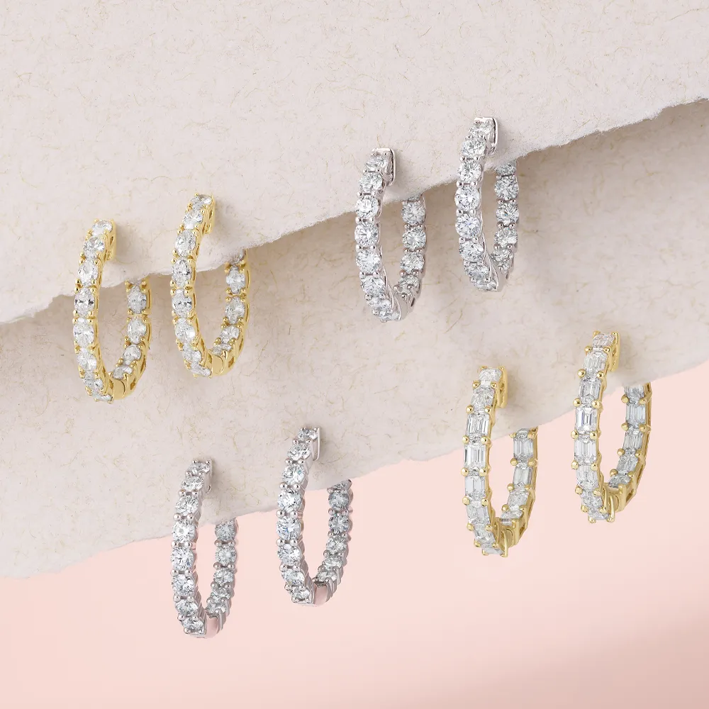 Gold and silver hoop earrings with diamonds displayed on a textured surface.