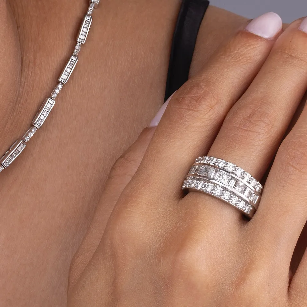 Close-up of a hand wearing a diamond ring and necklace from Heartland Gold Jewelry Store.