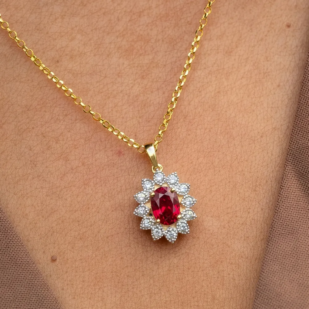 Gold necklace with a red gemstone pendant surrounded by small diamonds on a person's neck.