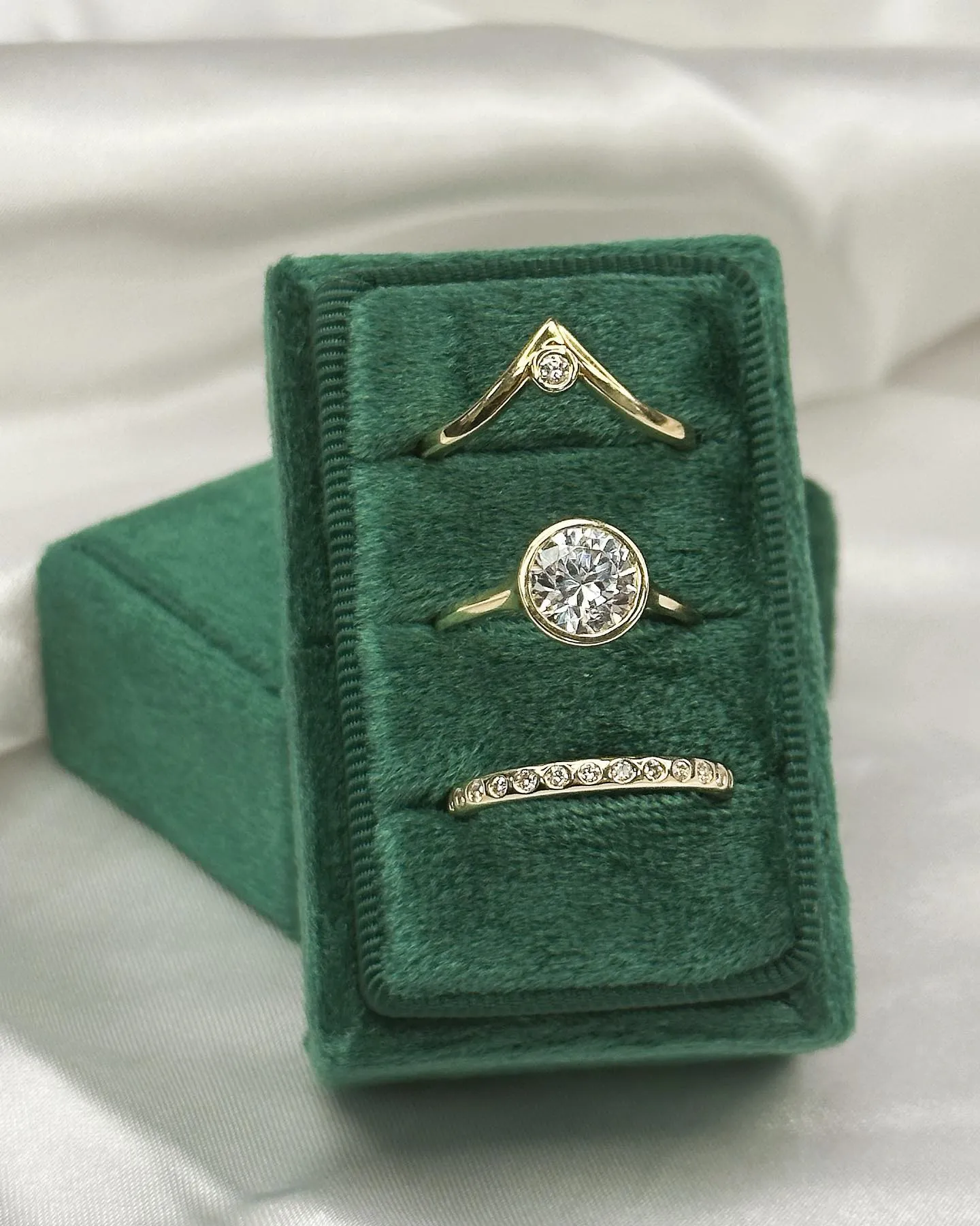 Two diamond engagement rings, one silver and one gold, with sparkling stones on a light background.
