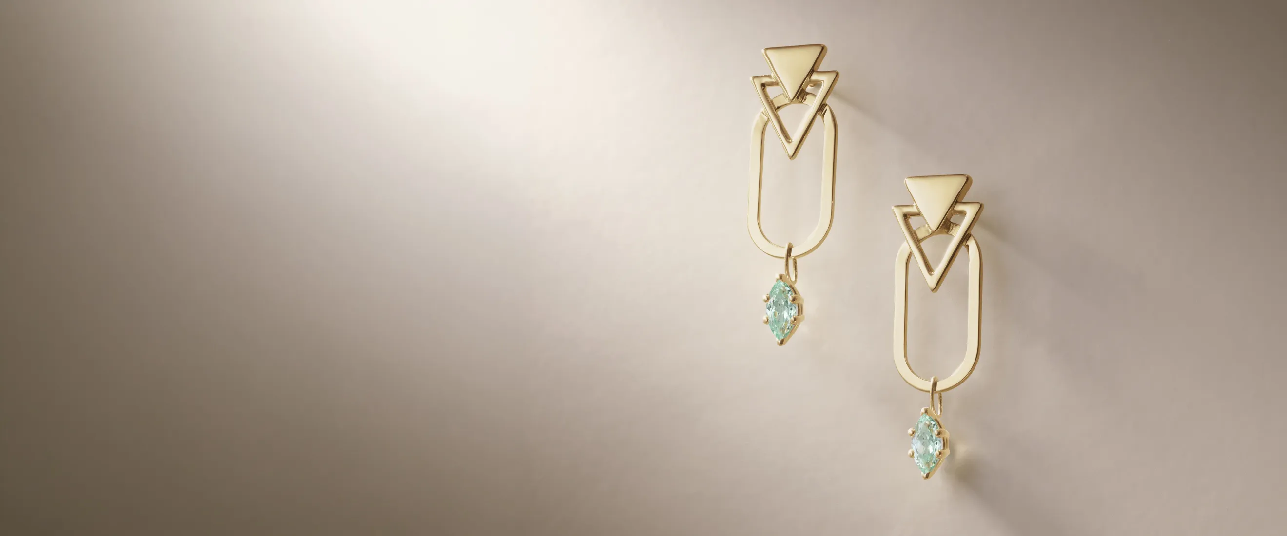Elegant gold earrings with geometric shapes and blue gemstones.