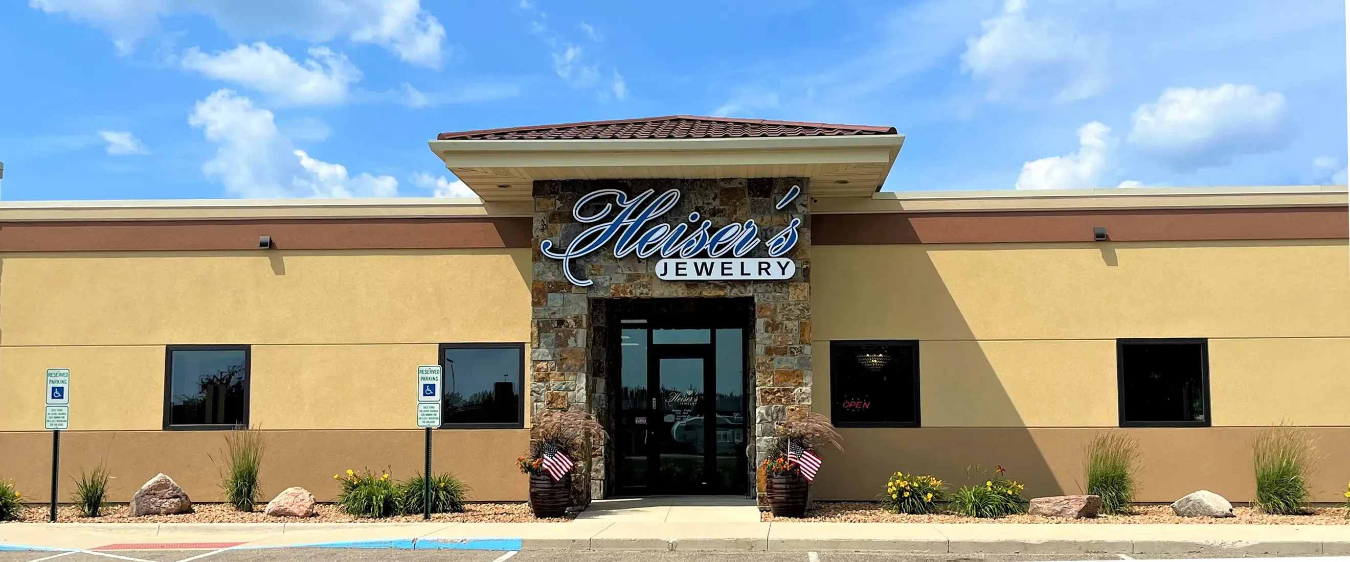 Heiser's Jewelry storefront with stone accents and signage under a blue sky.