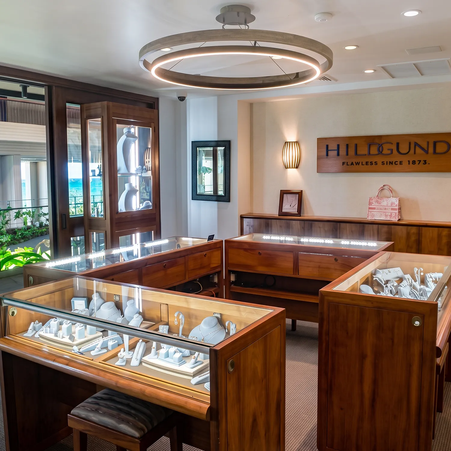 Elegant jewelry store interior with wooden display cases and modern lighting.