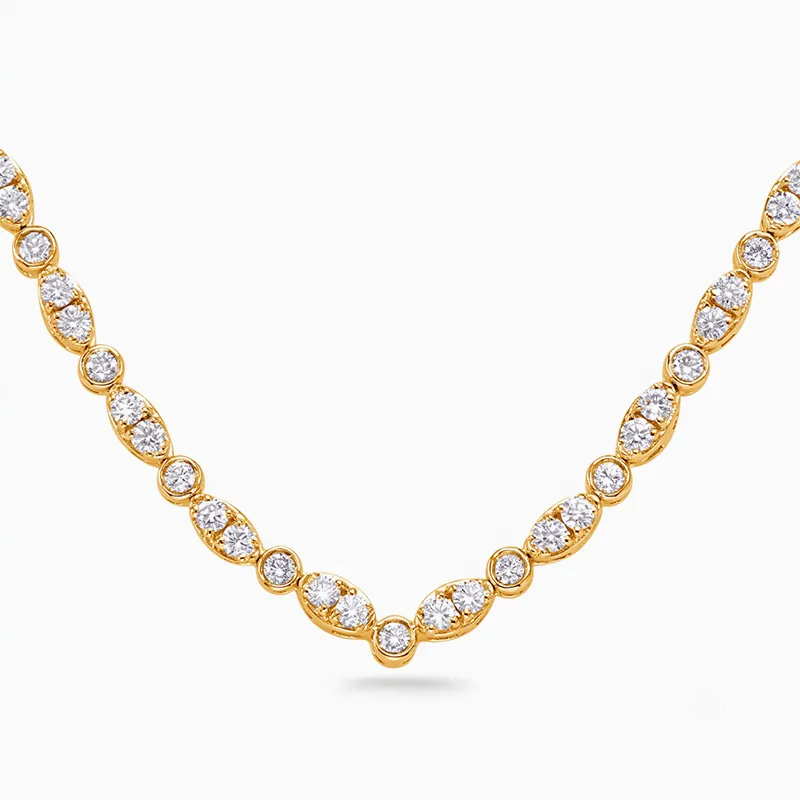 Gold necklace with round and marquise diamond clusters on a white background.