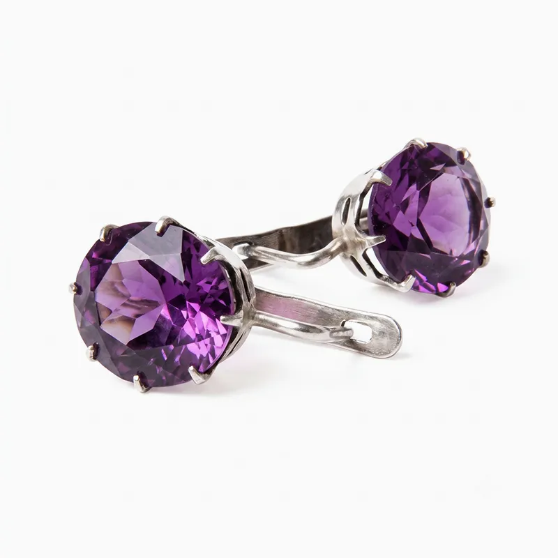 Purple gemstone cufflinks with silver settings on a white background.