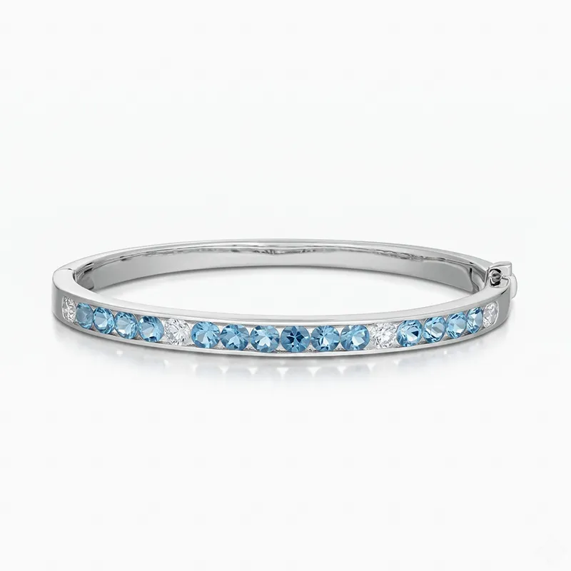 A silver bracelet with blue and clear gemstones set in a row.