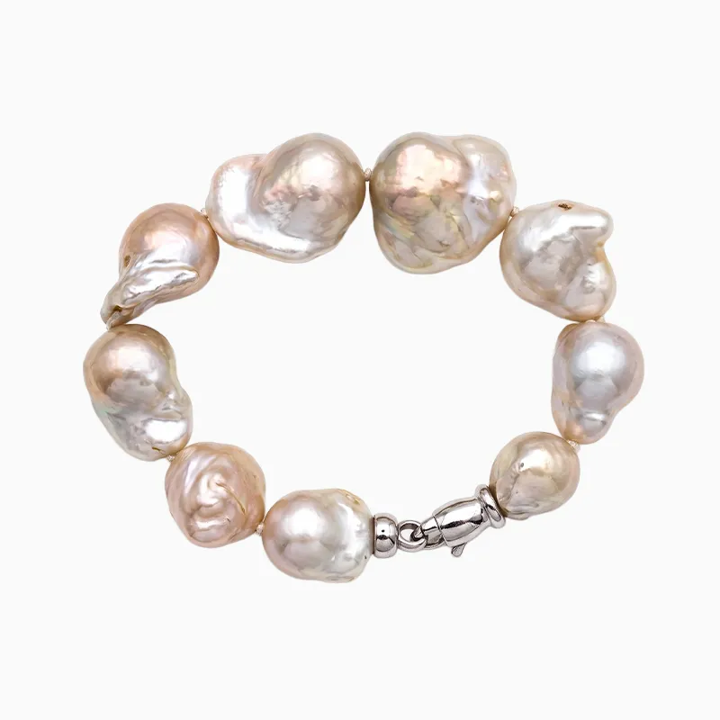 Baroque pearl bracelet with irregularly shaped pearls and a silver clasp on a white background.