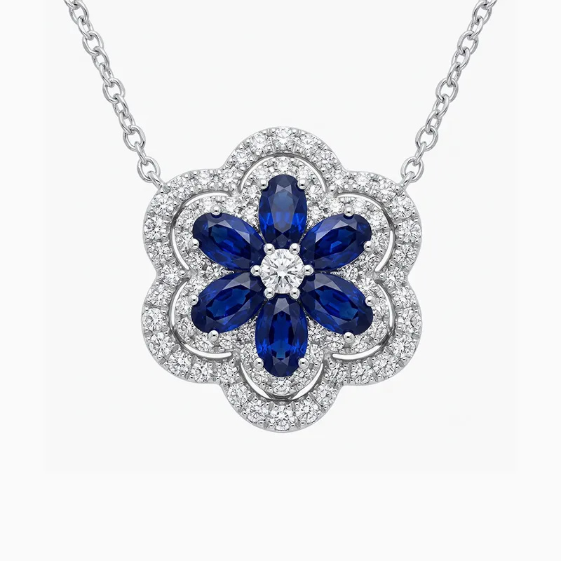 A floral pendant with blue gemstones and diamonds on a silver chain.