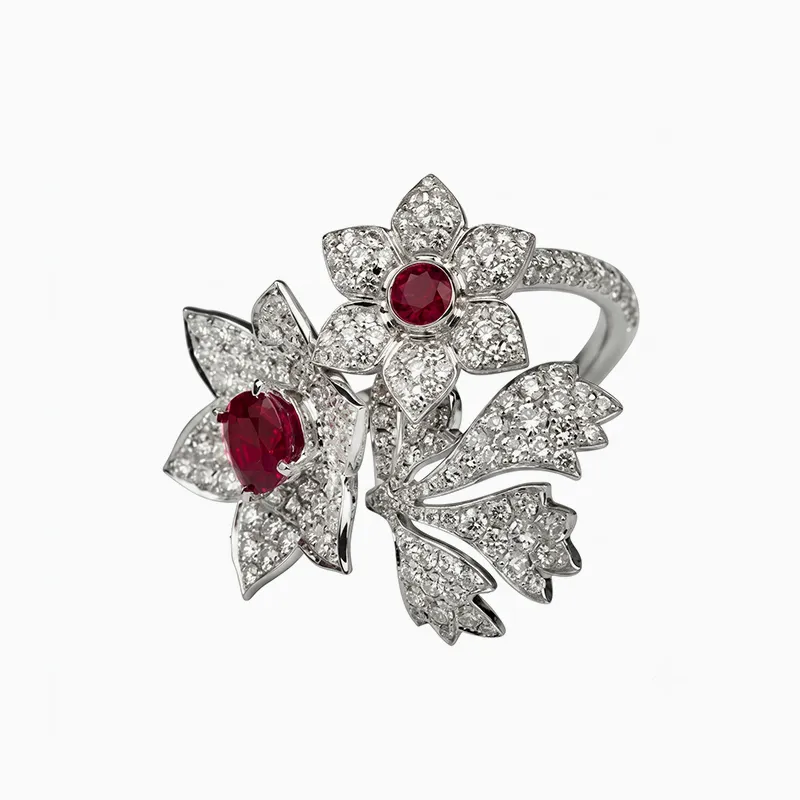 A floral-themed ring with diamonds and ruby accents on a white background.
