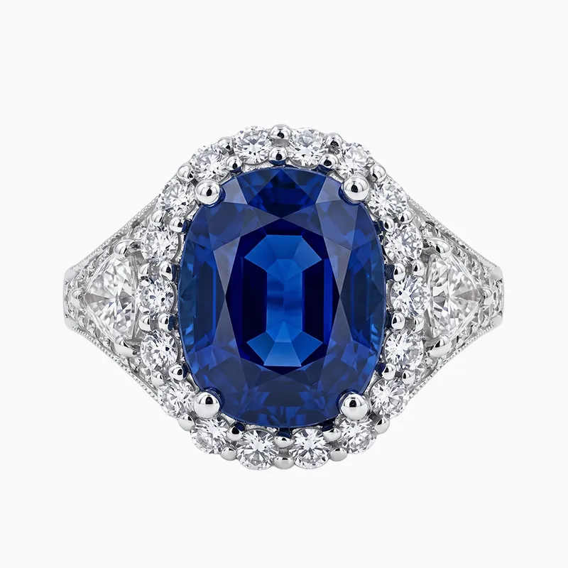 A sapphire ring with a large blue gemstone, surrounded by diamonds on a silver band.