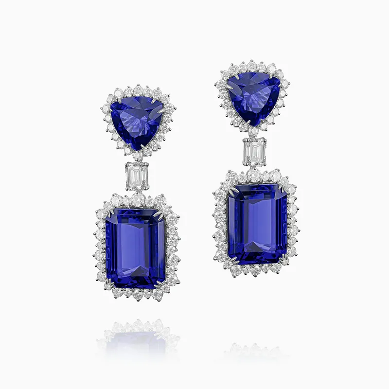 Elegant earrings with large blue gemstones and diamond accents on a white background.