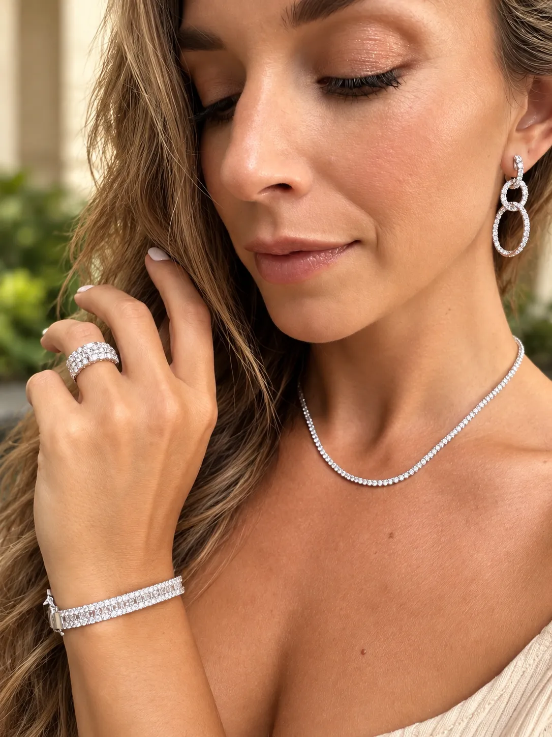 A woman wearing elegant diamond earrings, ring and bracelet.