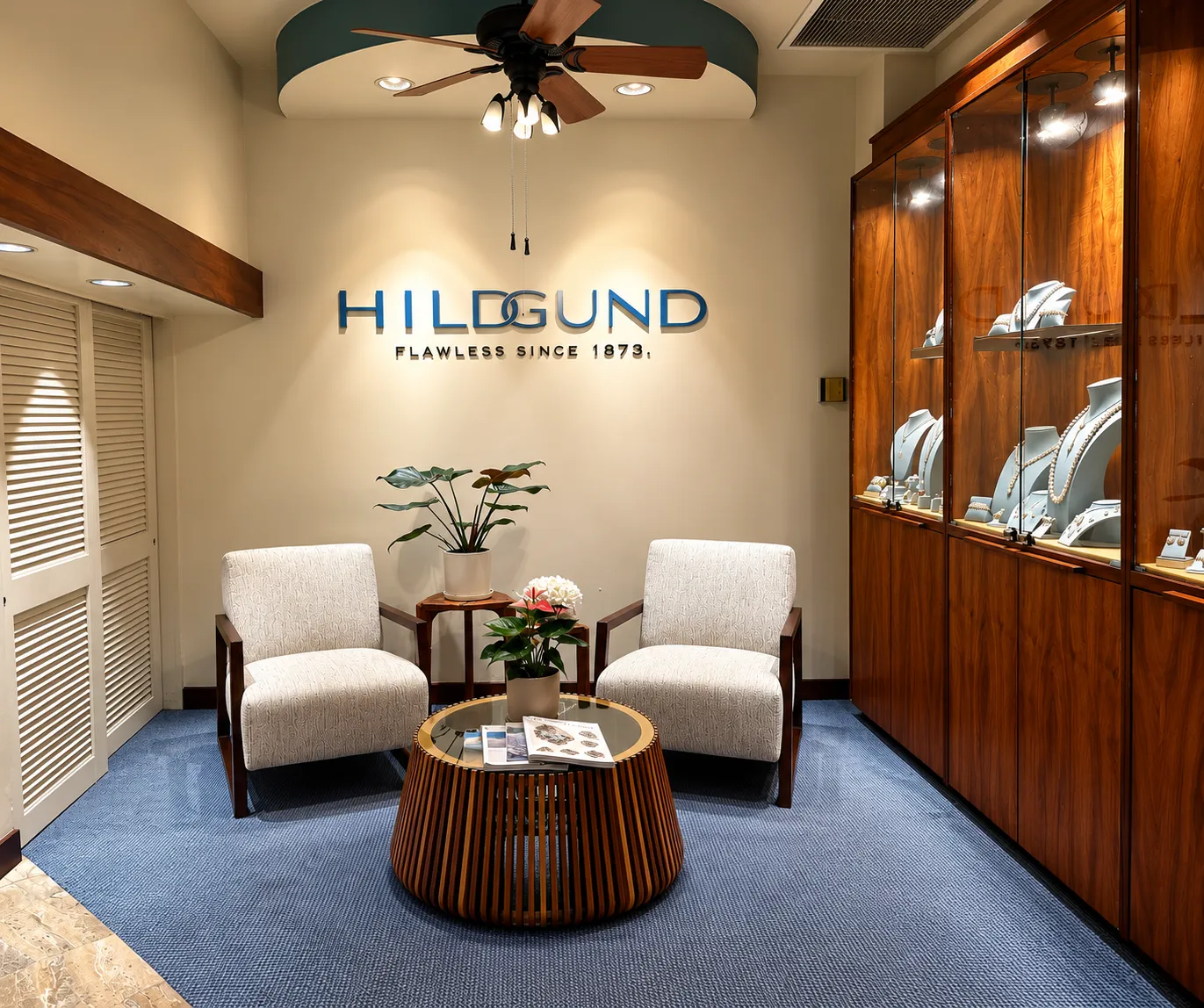 Jewelry store interior with display cases, seating area, and decorative plants.