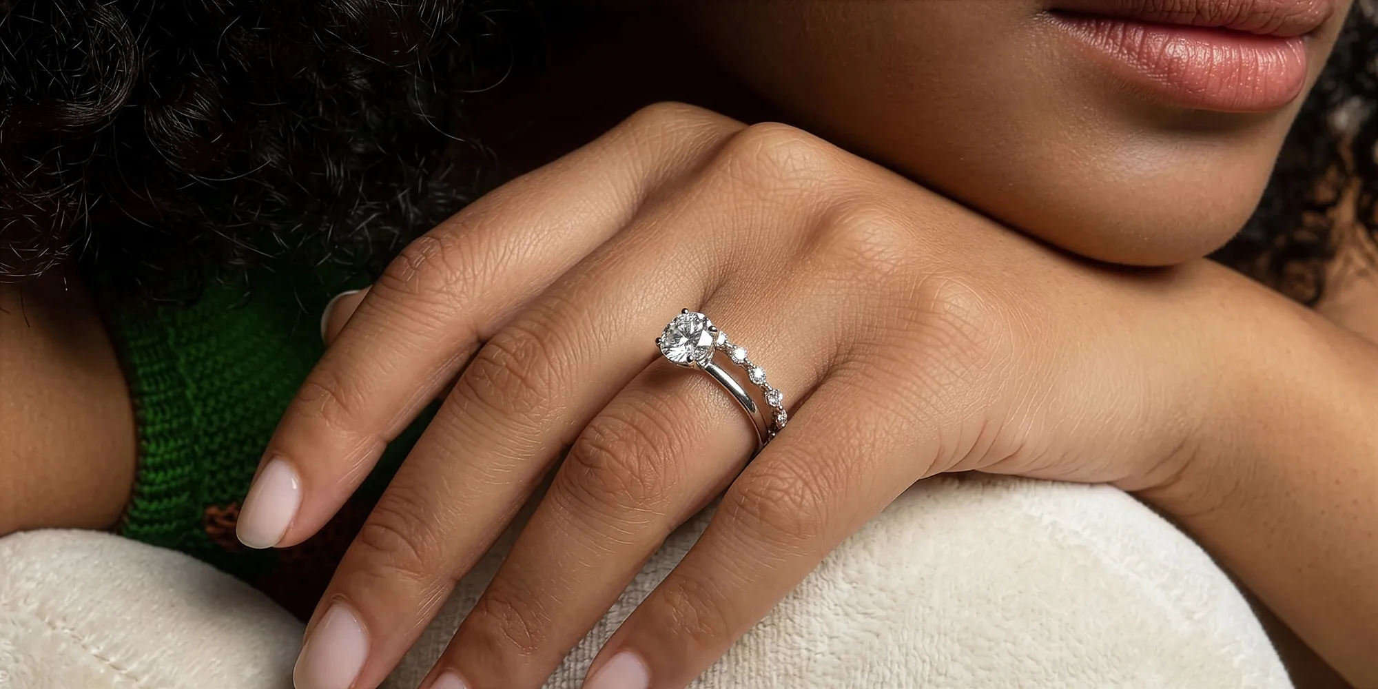 Close-up of a hand with a diamond engagement ring and wedding band.