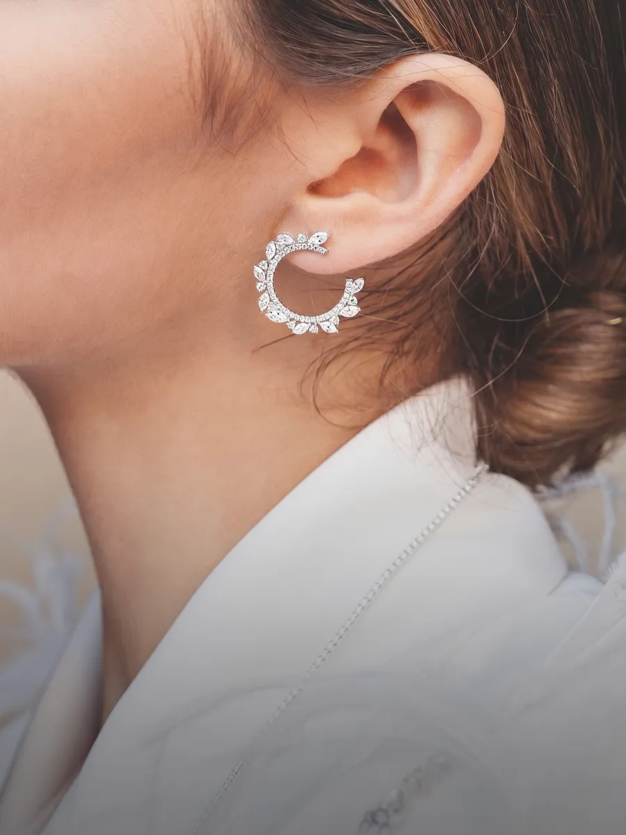 Elegant circular diamond earrings worn by a person. Shop earrings at Hingham Jewelers.
