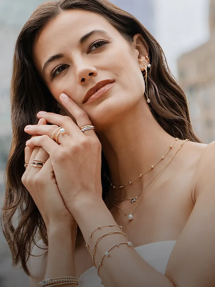 Woman wearing layered necklaces, rings, and bracelets. Click to shop new arrivals at Hingham Jewelers.