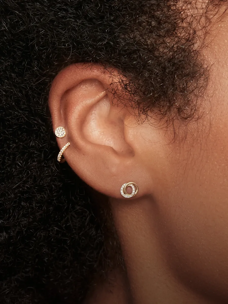 Close-up of an ear with three earrings, showcasing Hingham Jewelers' Signature Collection.