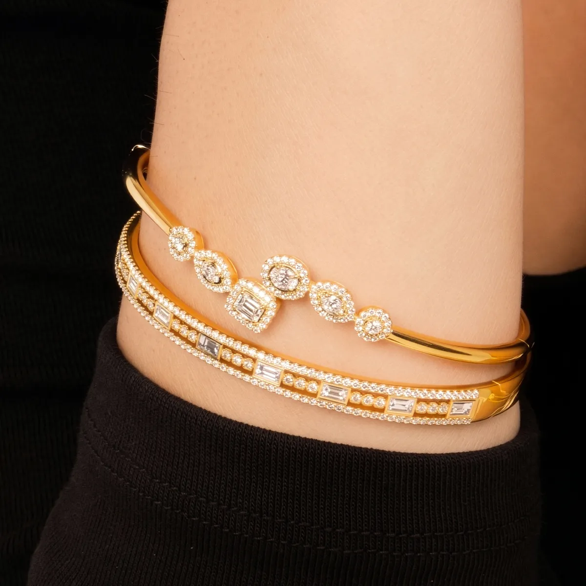 Gold and diamond bracelets on a wrist, showcasing elegant jewelry design.