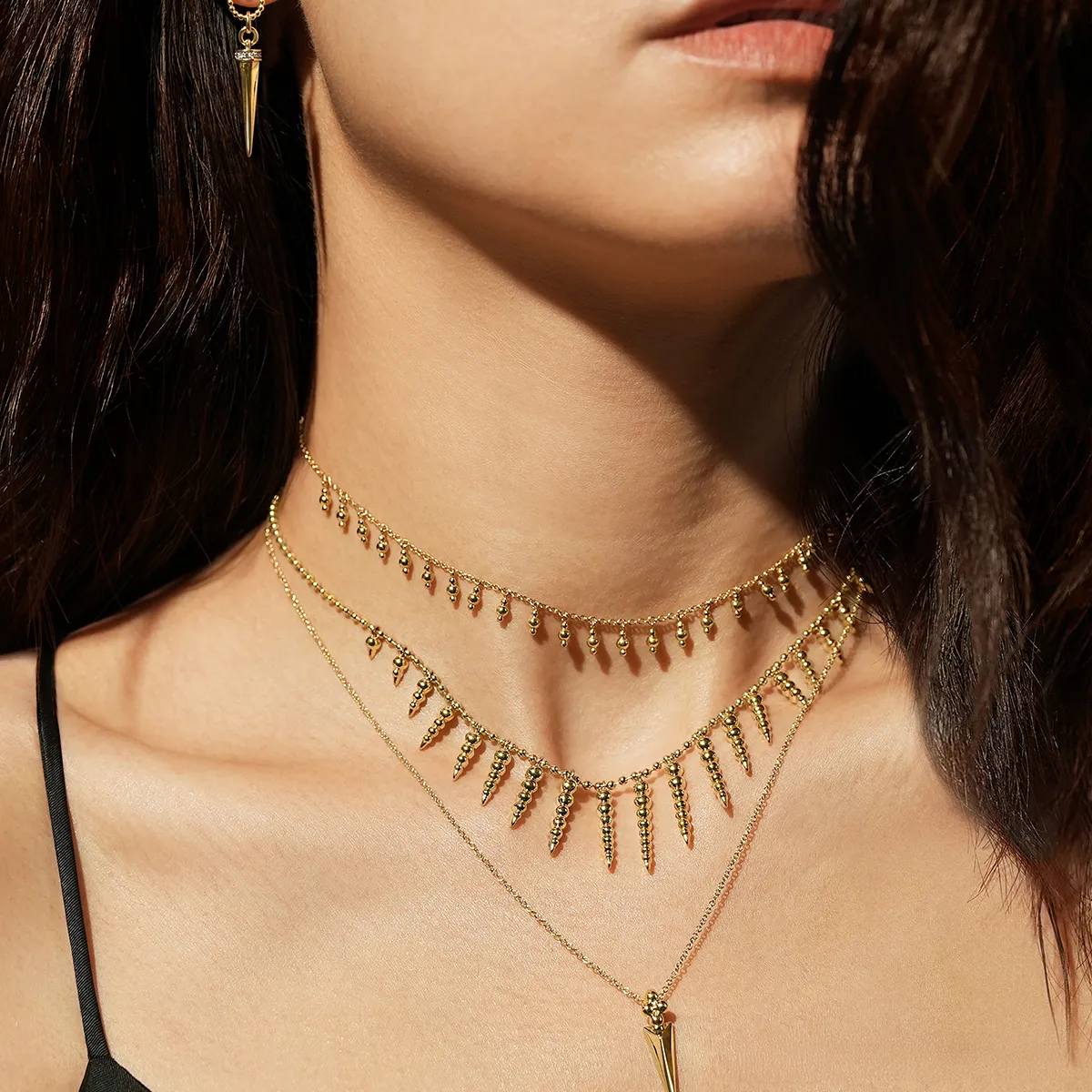 Gabriel and Co fashion jewelry collection featuring layered gold necklaces and earrings.