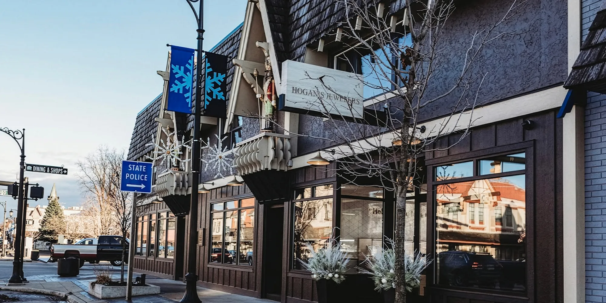 Street view of Hogan's Jewelers with snowflake decorations and nearby signs in Gaylord.