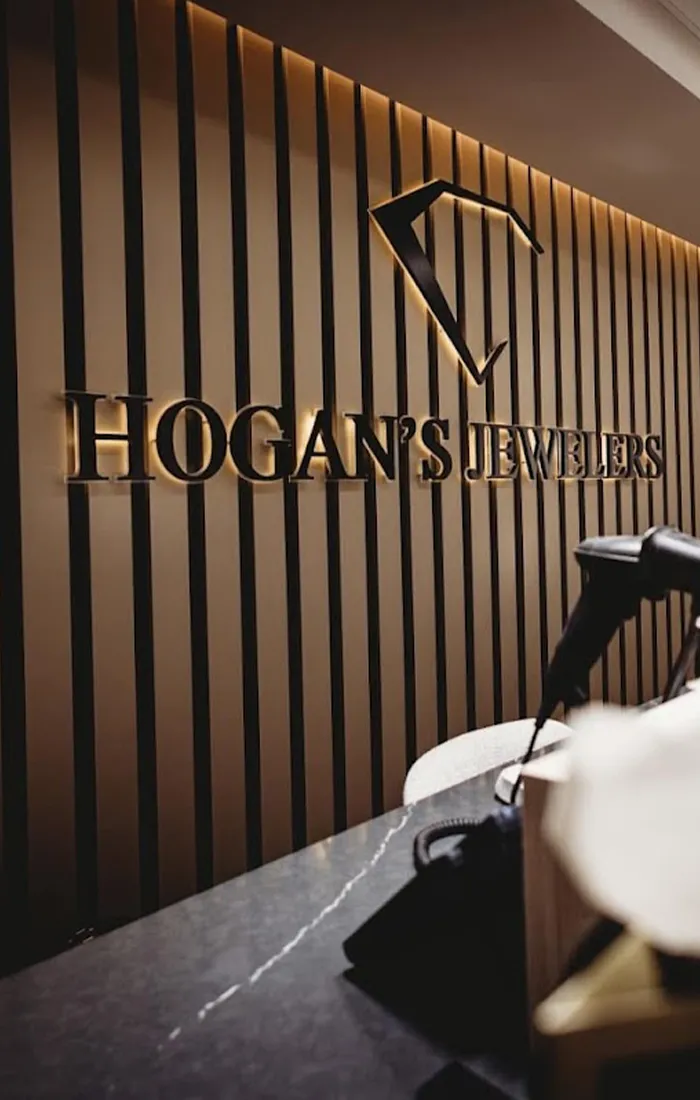 Hogan's Jewelers logo on a striped wall inside a jewelry store.