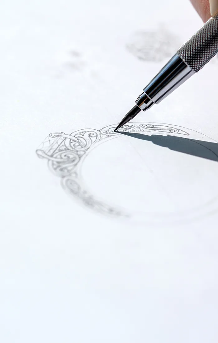 A detailed sketch of an ornate ring being drawn with a mechanical pencil.