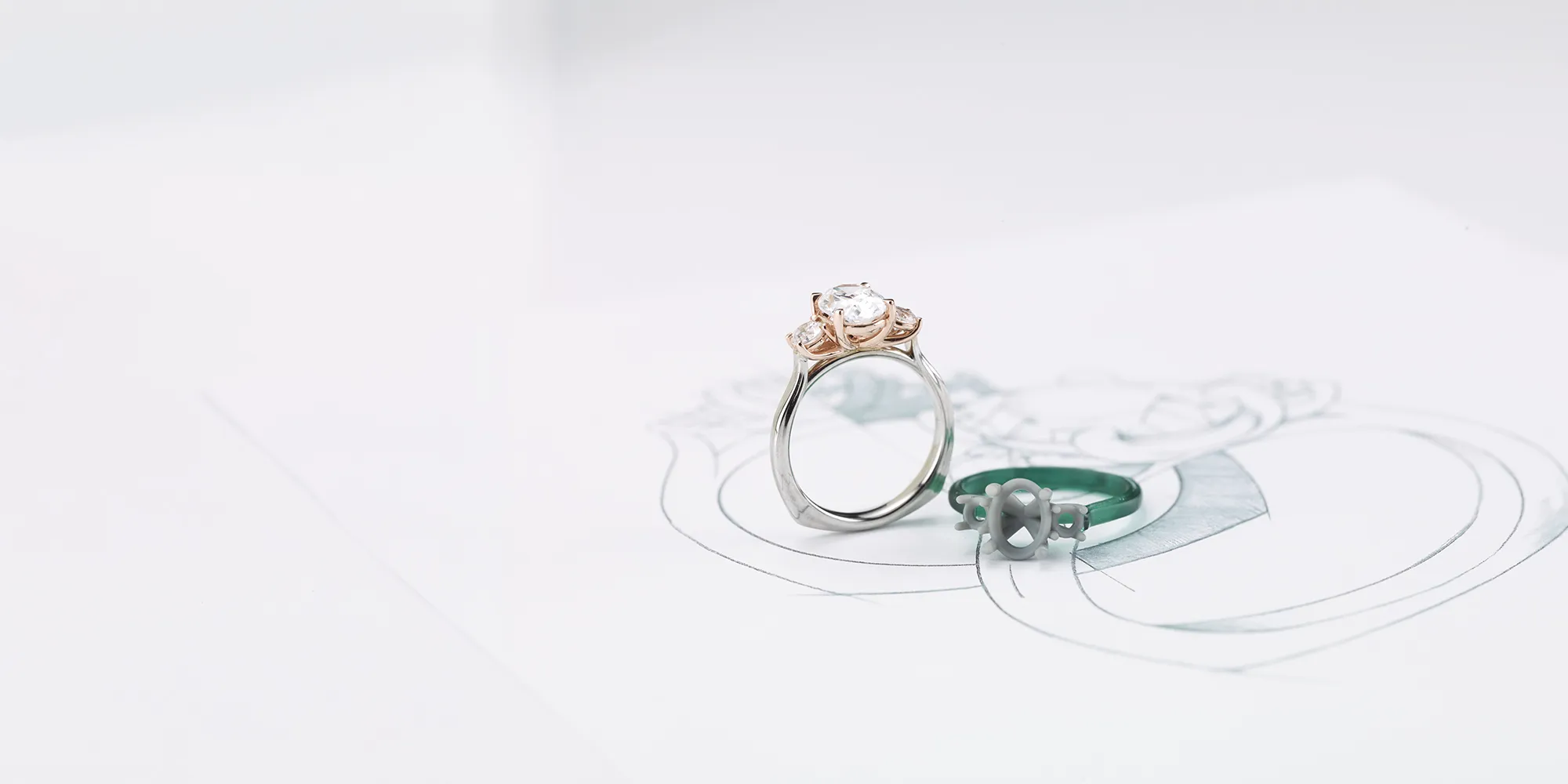 A diamond ring with a rose gold setting on a jewelry design sketch.
