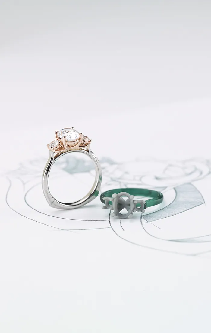 A diamond ring with a rose gold setting on a jewelry design sketch.