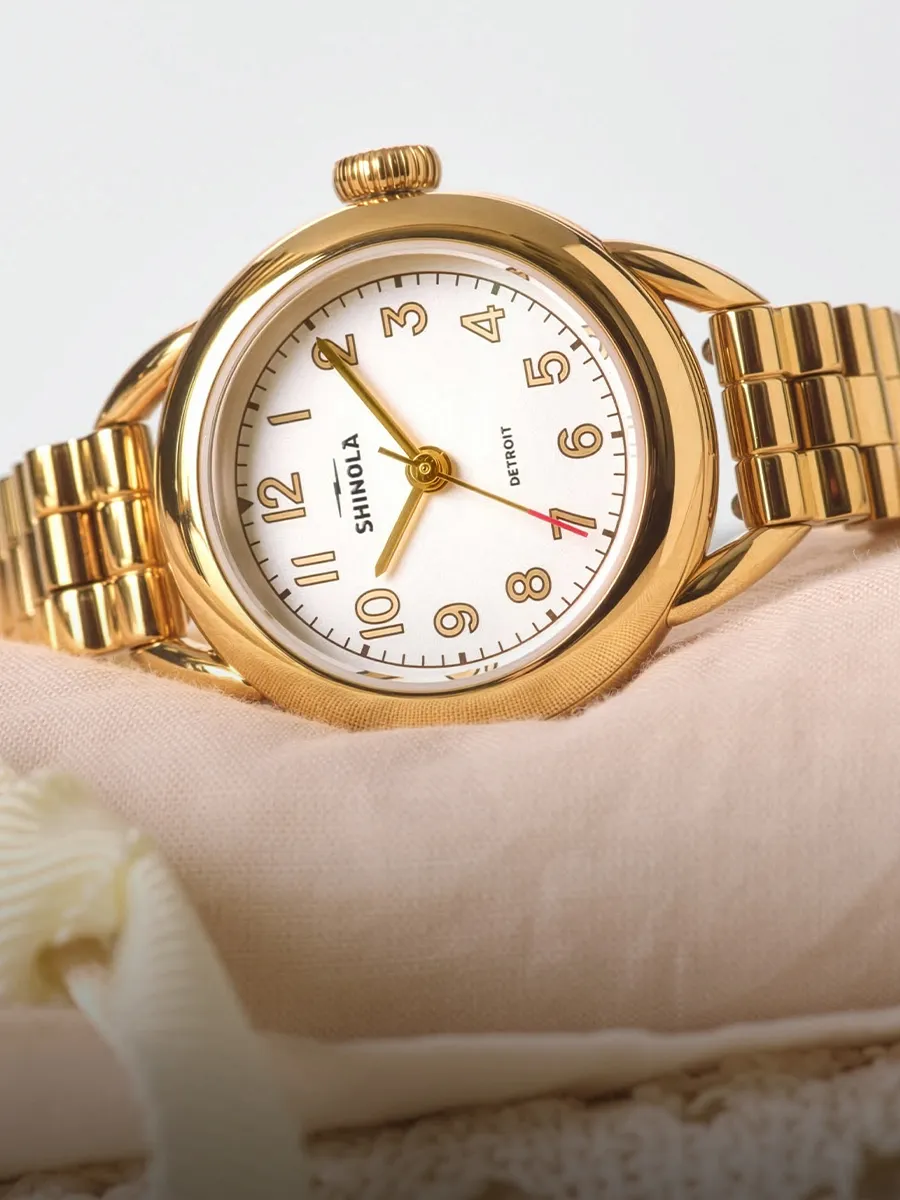 Two luxury watches with metal bands, one gold with a black dial and one silver with a white dial, displayed on a gradient backgr