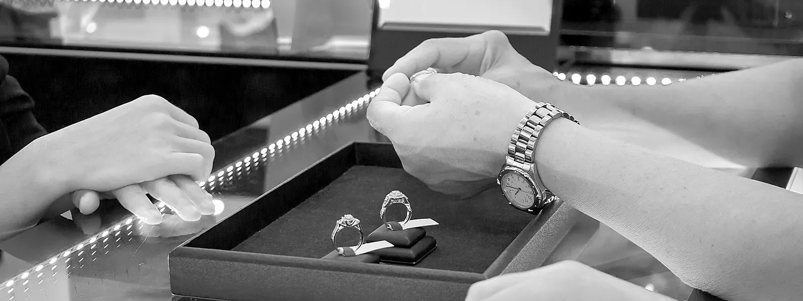 Salesperson examining engagement rings at Holliday Jewelry in Klamath Falls. Click to apply for a salesperson position.