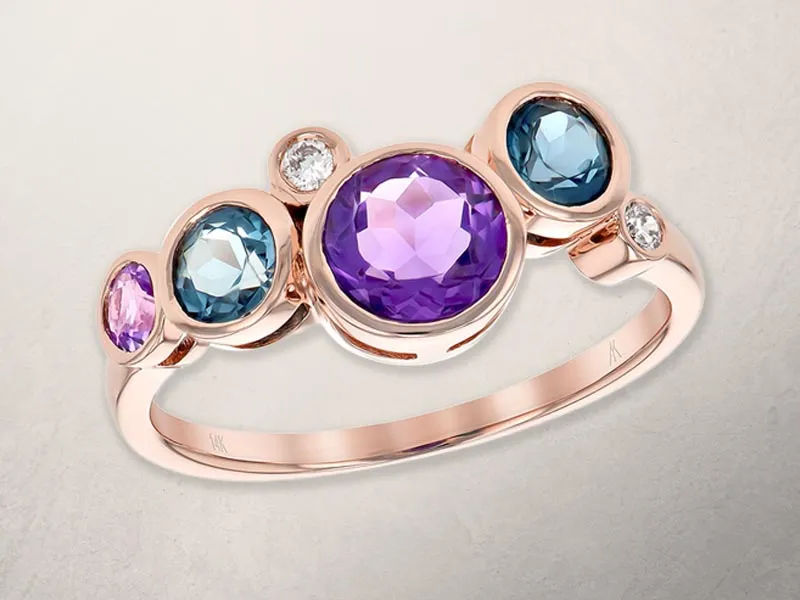 Colorful gemstone ring featuring purple, blue, and pink stones set in rose gold. Click to see more at Holliday Jewelry.