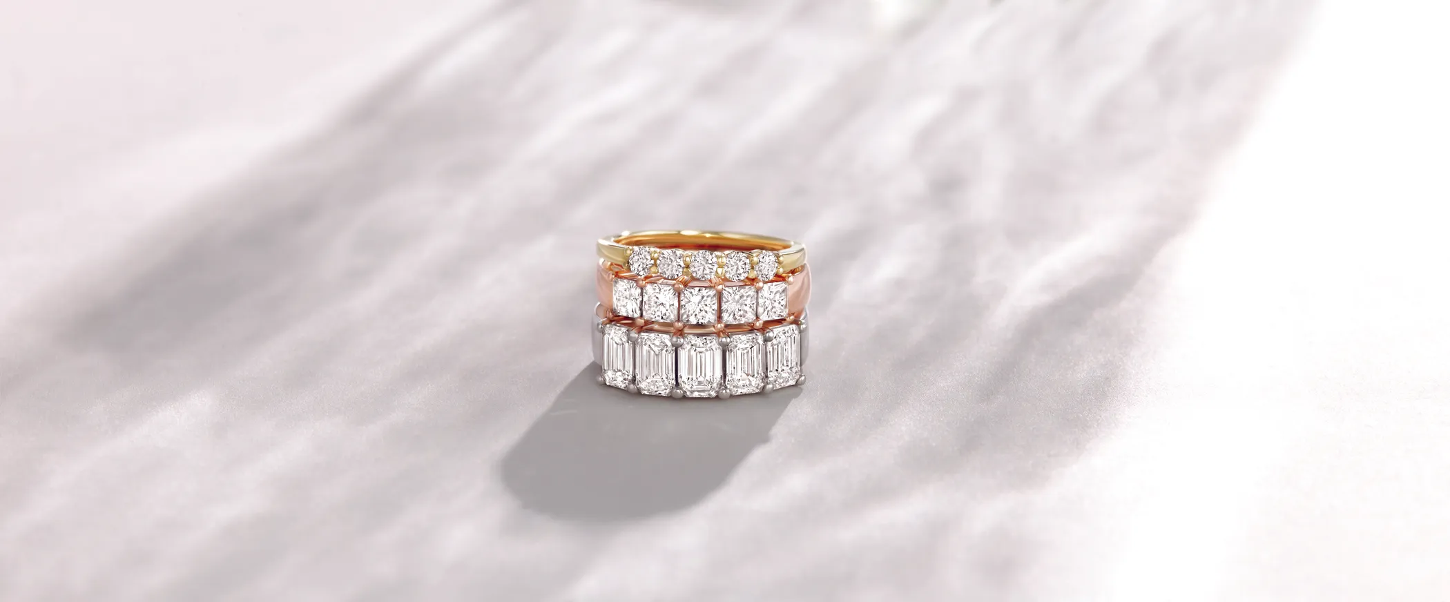 Two elegant gold wedding bands with intricate designs and diamond accents.