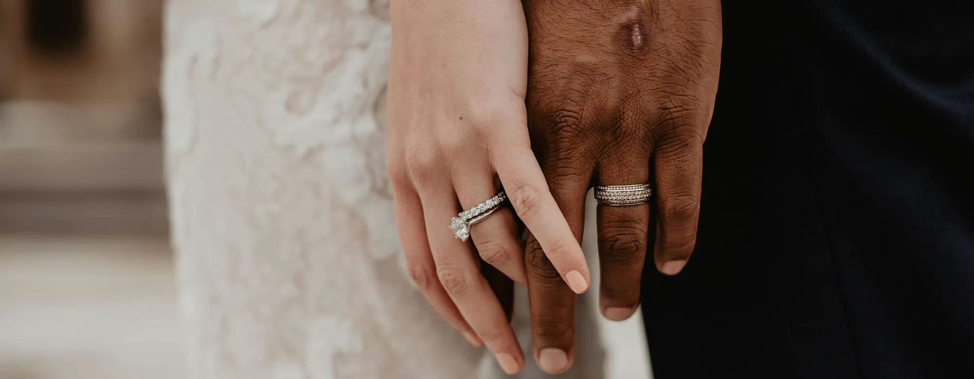 Close-up of a couple's hands showing wedding rings, symbolizing love and commitment.