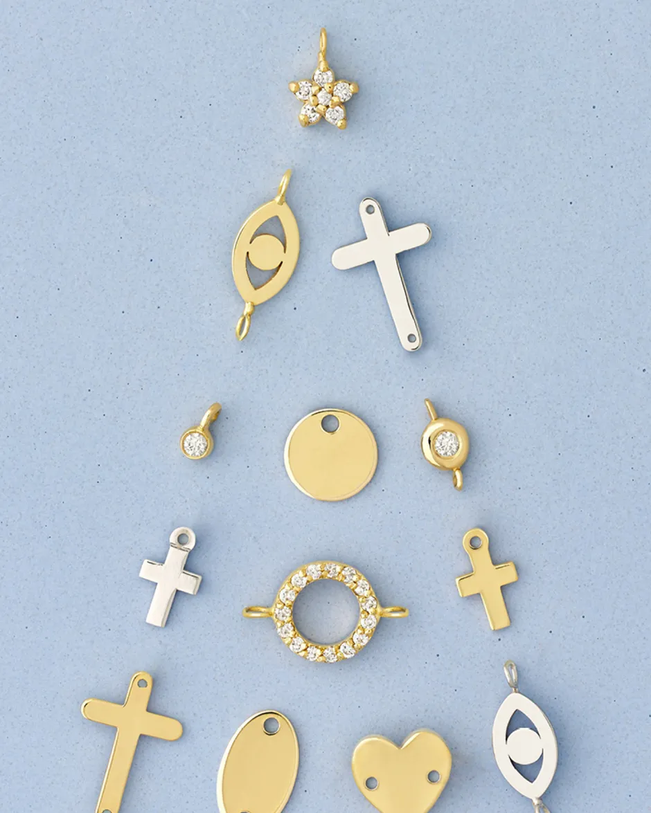 Collection of gold and silver charms including crosses, hearts, and a star, displayed on a blue background.