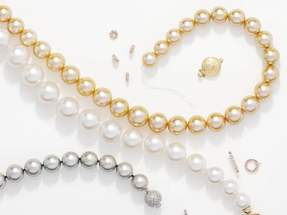 Elegant pearl necklaces in gold, silver, and white, with additional jewelry pieces scattered around.