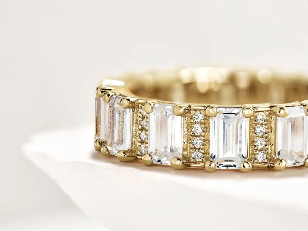 Elegant gold wedding band featuring emerald-cut stones and diamonds, perfect for special occasions.