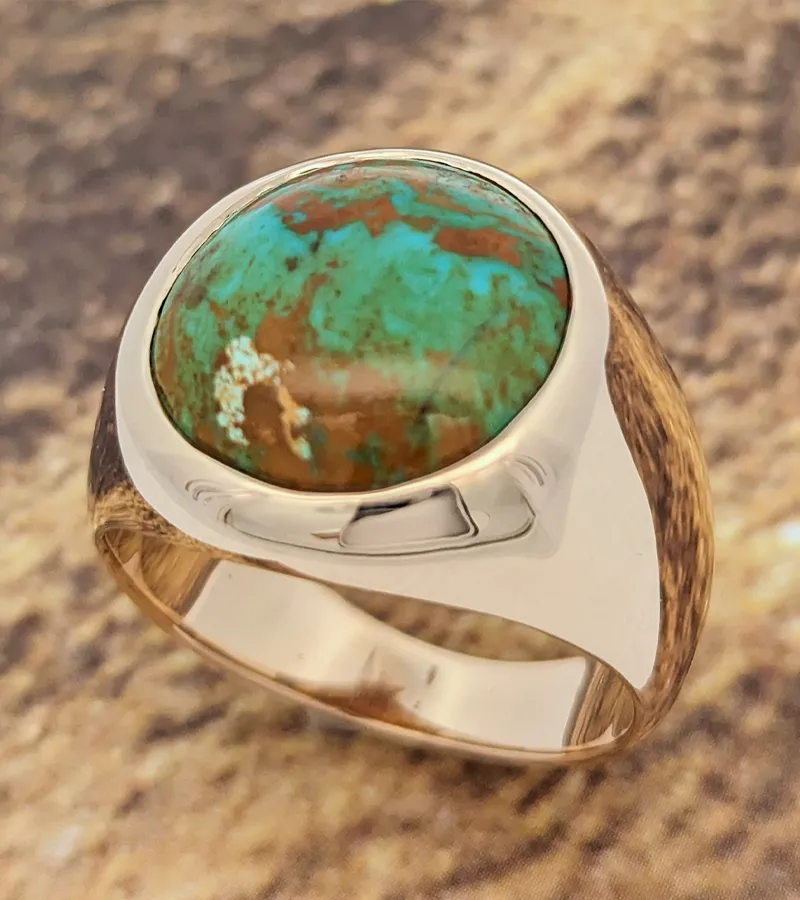 Turquoise gemstone ring set in silver, showcasing a vibrant blue-green color with earthy brown accents. Visit for custom designs