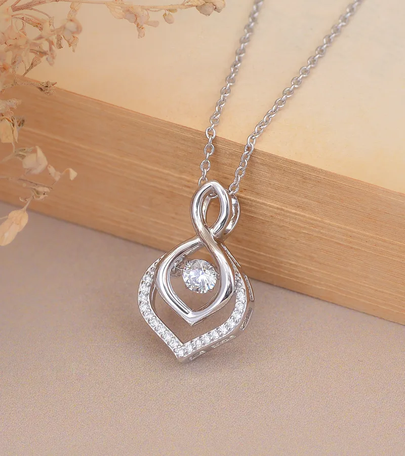Elegant silver necklace with a diamond pendant, featuring intertwined designs. Click here to shop diamonds