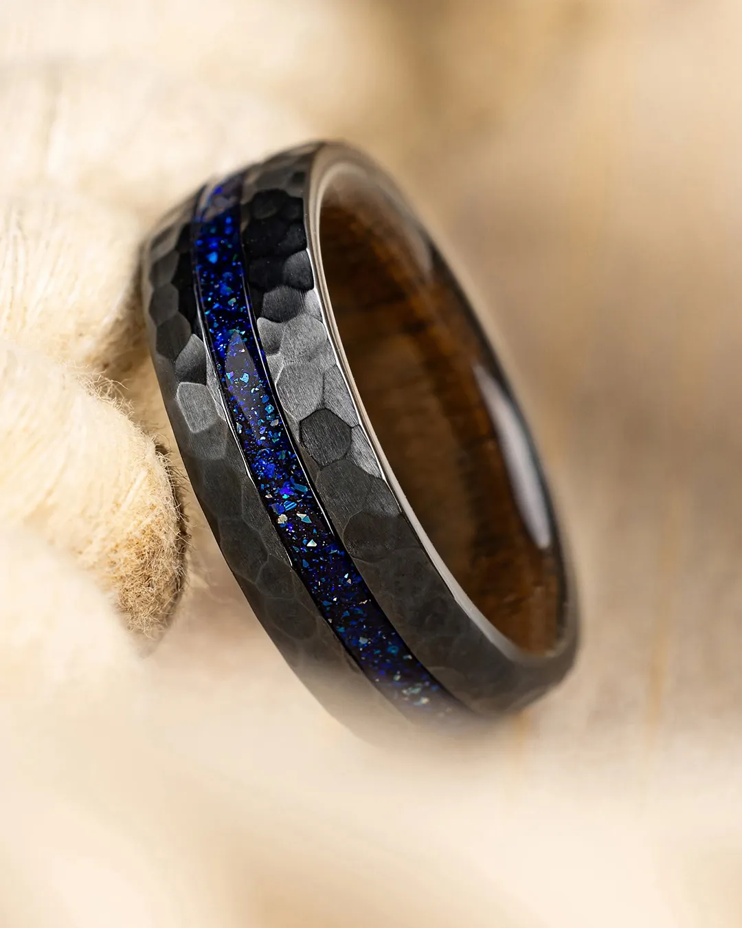 Hand sketching a detailed men's ring design on paper. Click to build your band.
