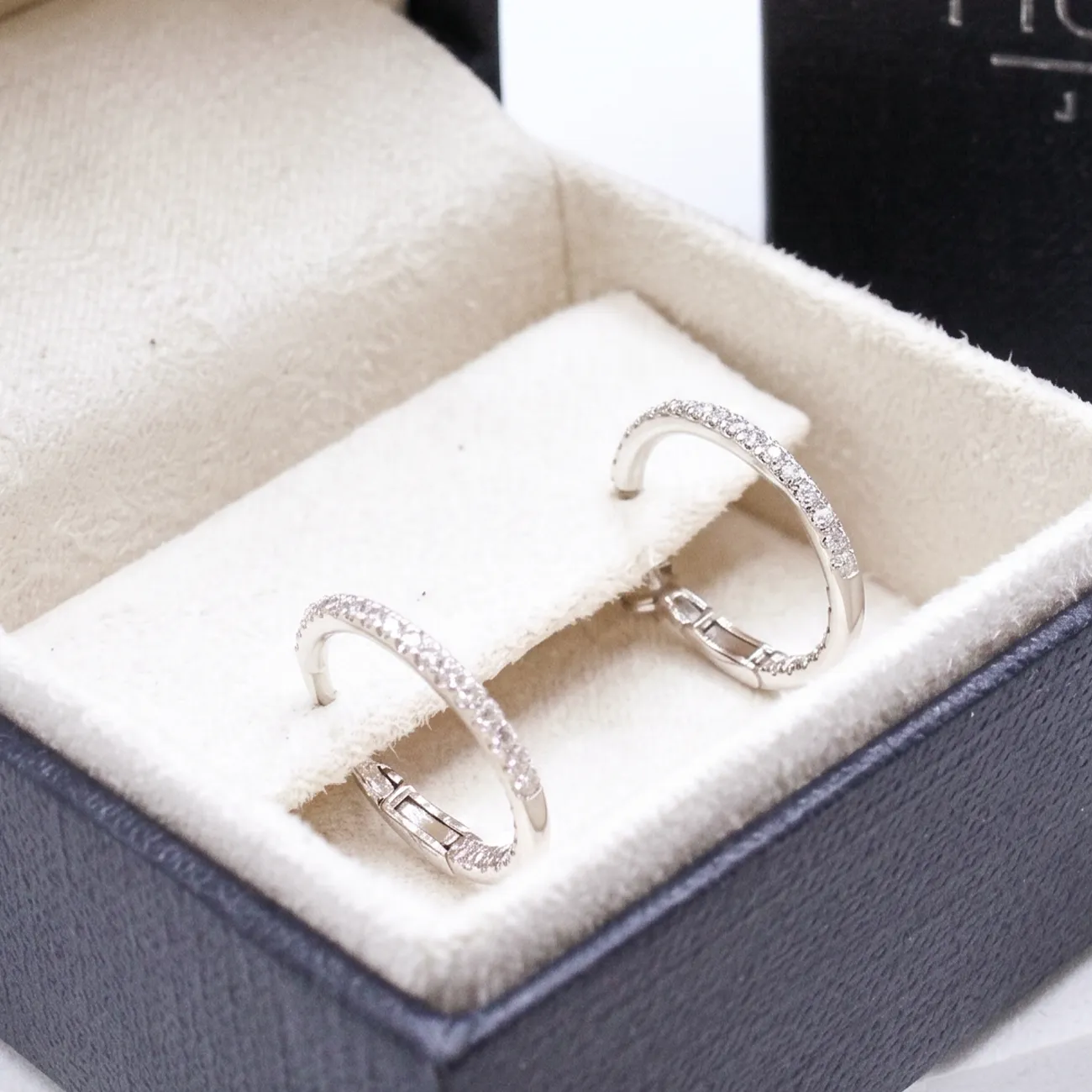 Diamond hoop earrings in a jewelry box.