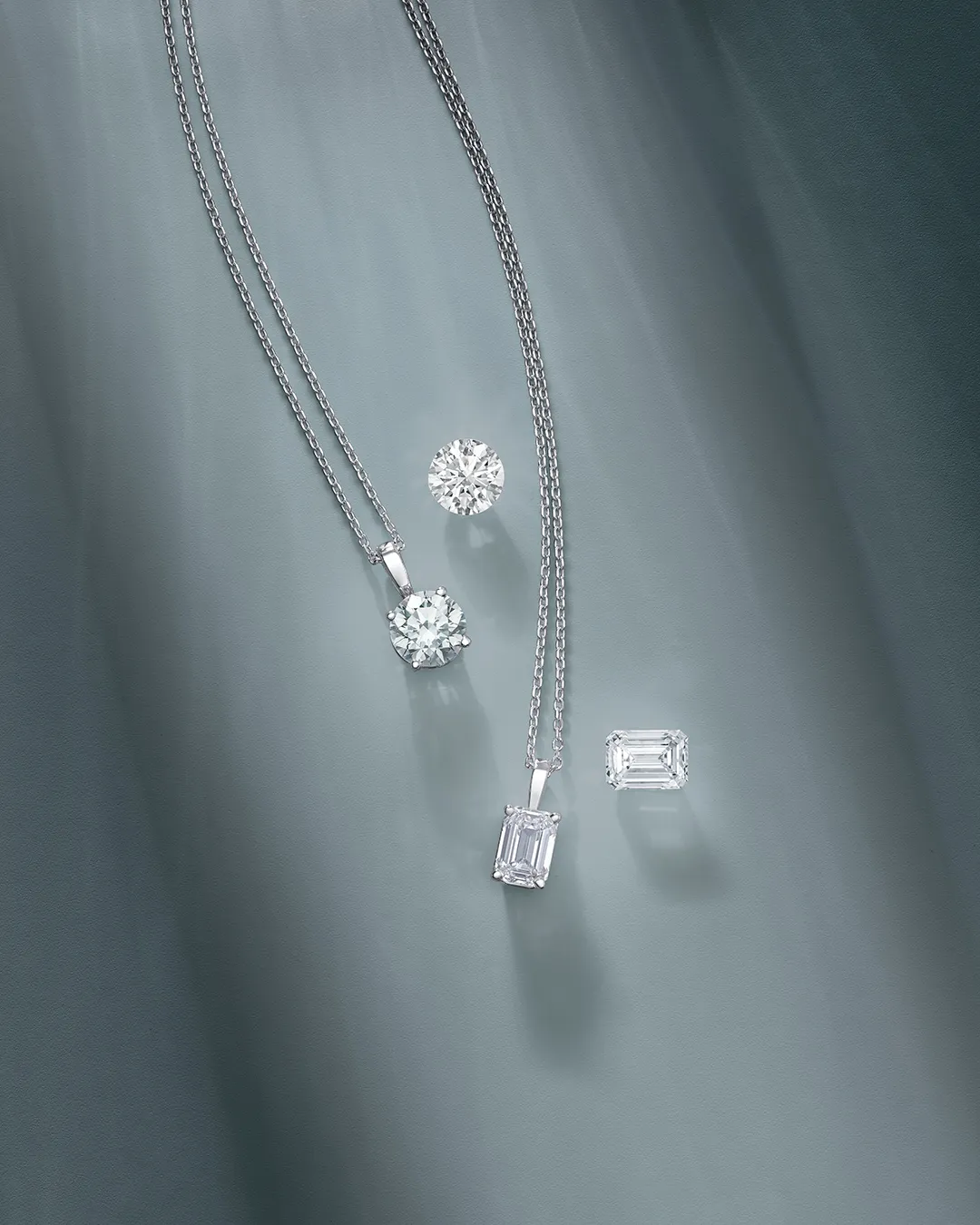 Lab-grown diamond necklaces and earrings on a soft blue background. Shop Now at Huffords Jewelry.