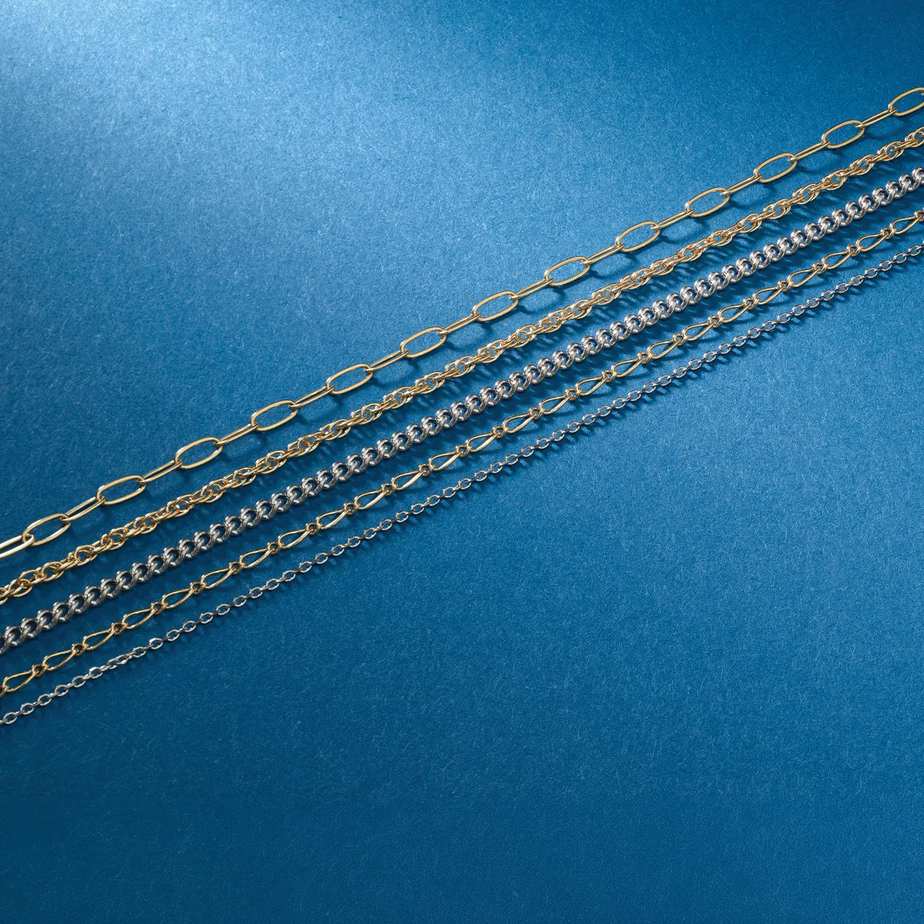 Gold and silver chains displayed diagonally on a blue background.