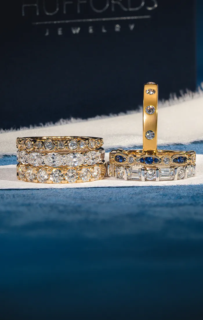 Elegant diamond and gemstone rings displayed on a white surface.