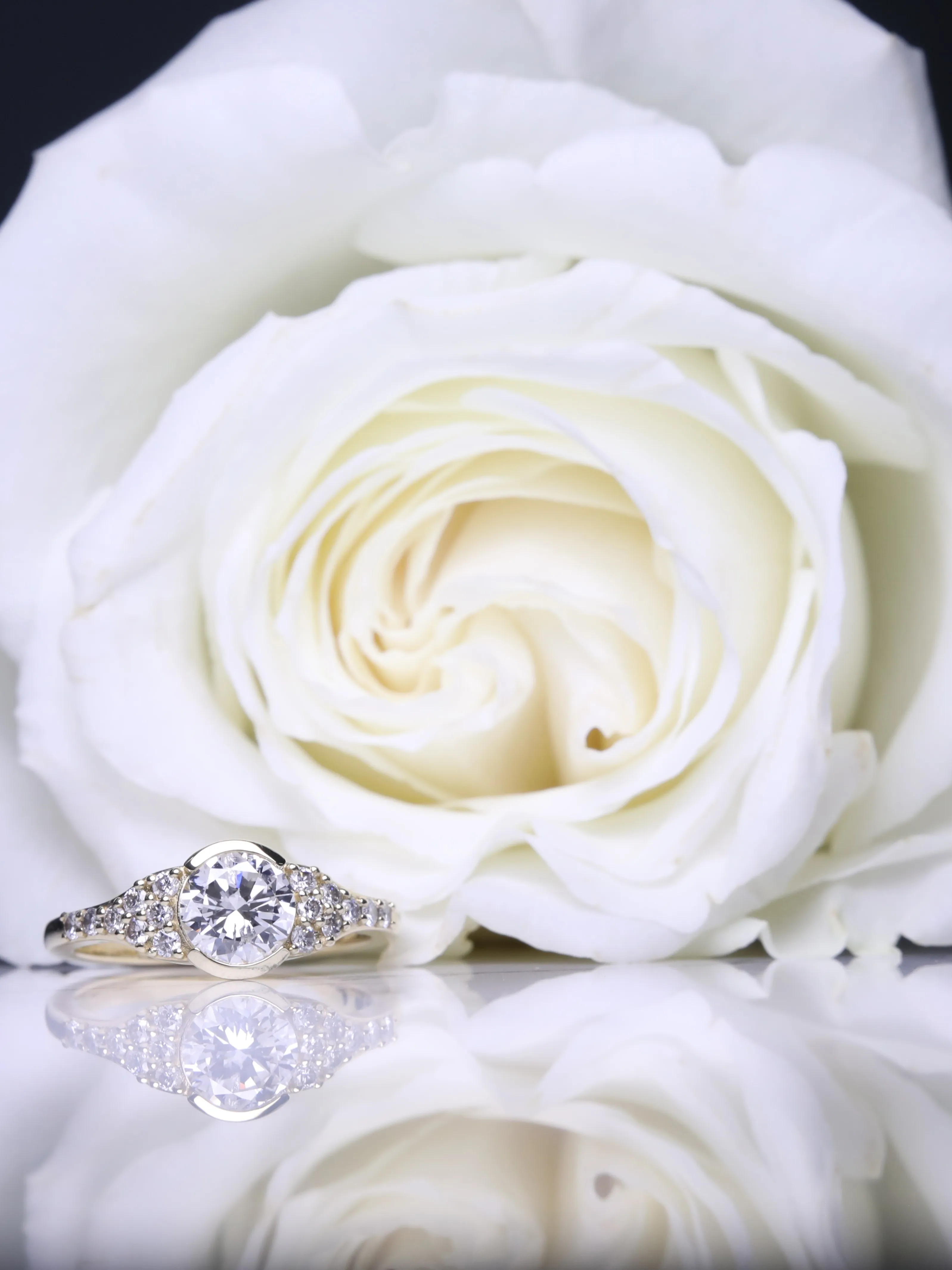 Gold flower ring with a blue gemstone and diamond center, showcasing fine jewelry craftsmanship.