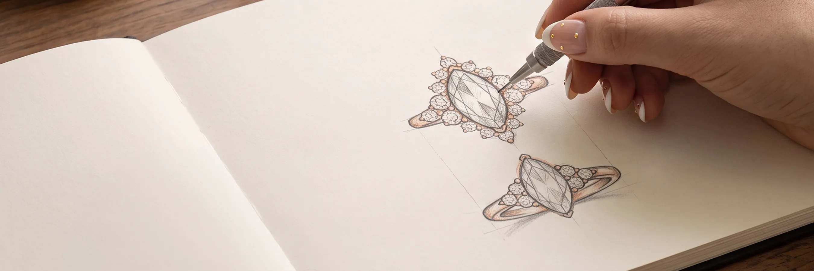 A hand sketching a detailed ring design with a pencil on paper.