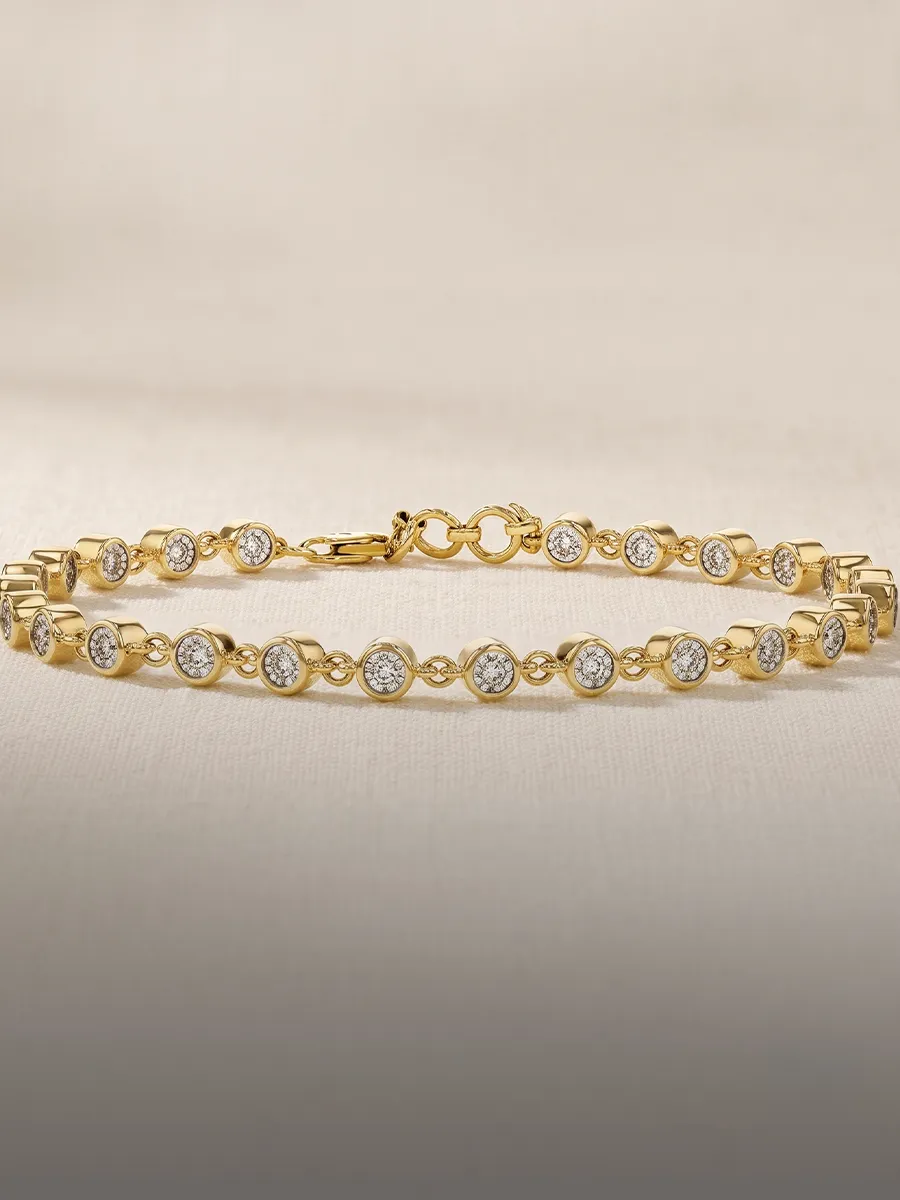 A gold bracelet with round diamond settings on a neutral background.