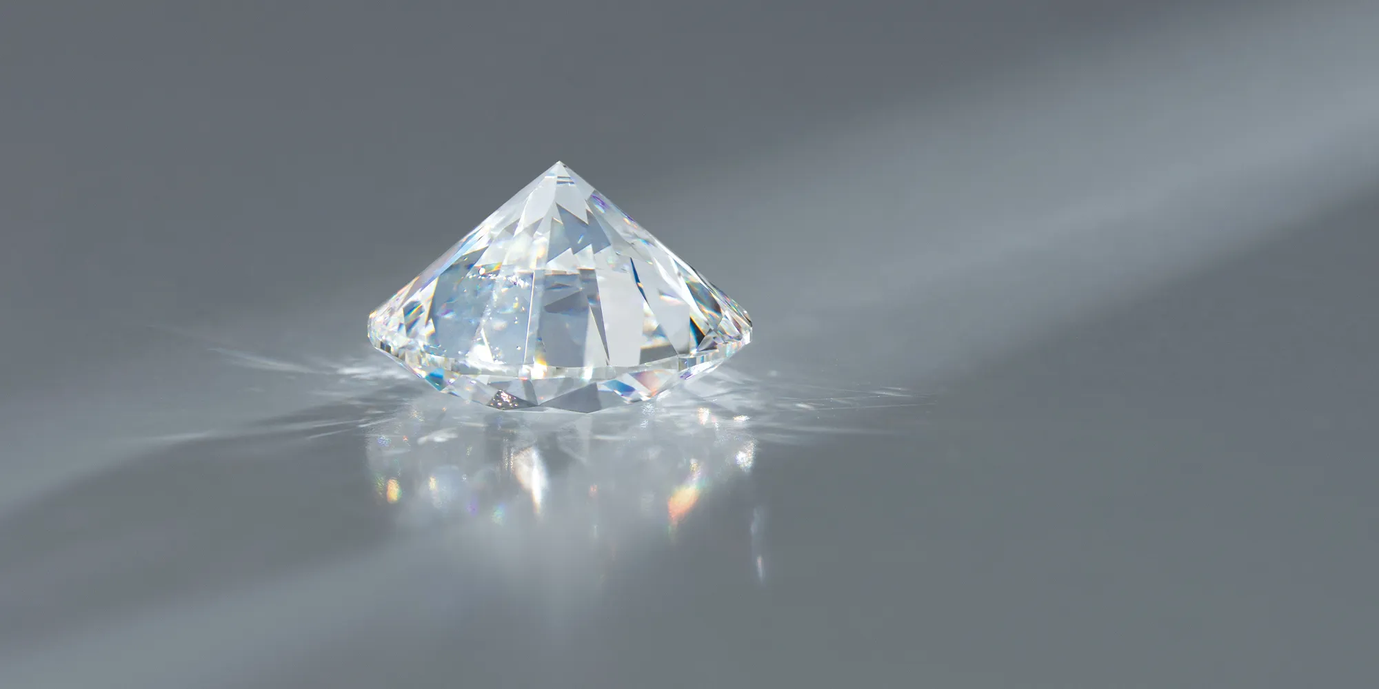 A sparkling diamond on a reflective surface with light dispersion.