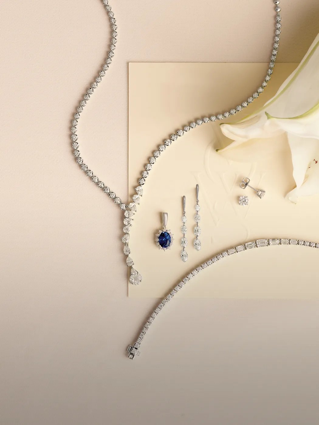 Elegant diamond and sapphire jewelry set displayed on a soft background.
